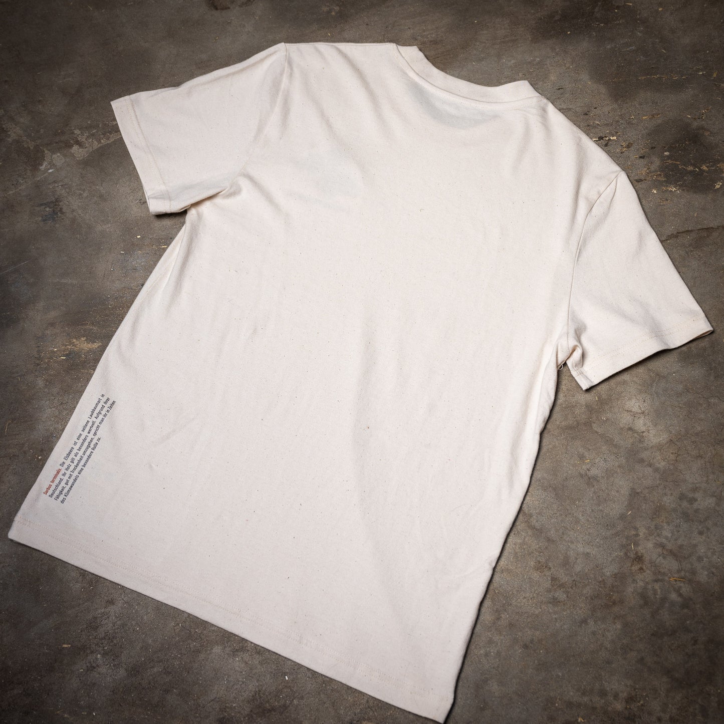 Rückseite des Waldshirt Elsbeere. An der Kante unten links ist ein kleiner Infotext aufgedruckt.